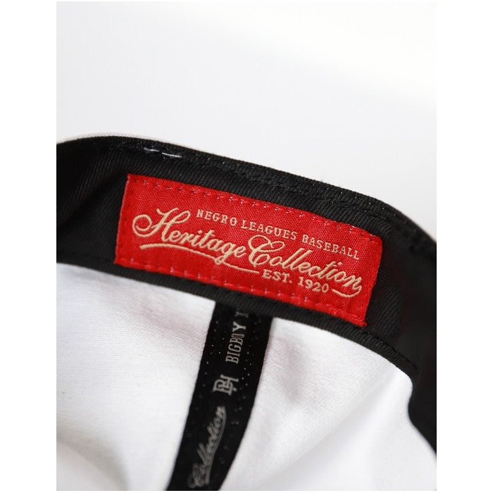 Brooklyn Eagles Heritage Snapback Baseball Cap (Inside) - Close-up of a red label on a black strap with 'Heritage Collection' text, on a white background.
