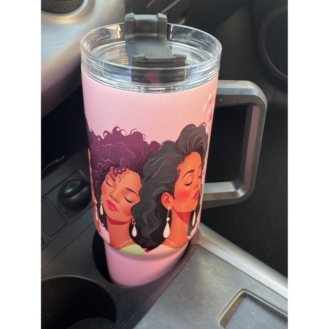 Alpha Kappa Alpha Ivy Love Sisterhood Tumbler with Handle (Lifestyle) - A pink handled travel tumbler with a clear lid and flip-top spout, featuring an illustration of two women with dark hair, resting in a car cup holder.