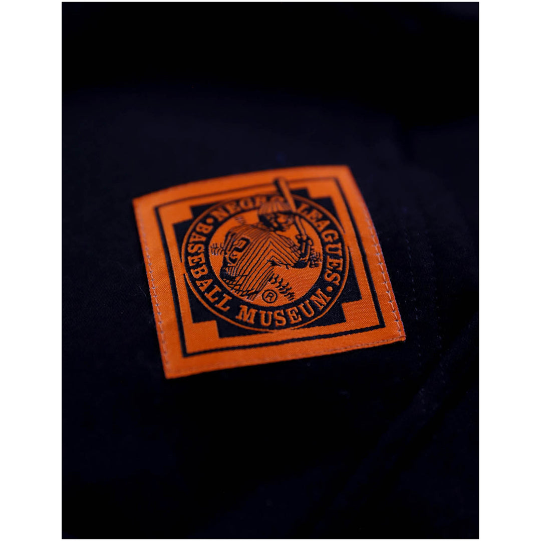 Baltimore Black Sox Heritage Hooded Sweatshirt (Front Detail 2) - A close-up of a square orange embroidered patch on a dark navy or black fabric, featuring the New York Giants logo and the text 'NEW YORK GIANTS MUSEUM'.