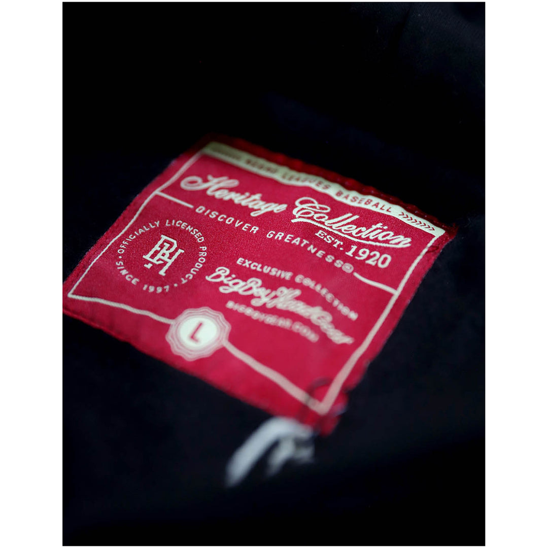 Baltimore Black Sox Heritage Hooded Sweatshirt (Front Detail 3) - A close-up of a red fabric brand label sewn onto a dark garment, showing the text 'Heritage Collection' and 'Polo Ralph Lauren'.