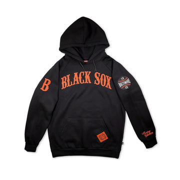 Baltimore Black Sox Heritage Hooded Sweatshirt (Front) - A black pullover hoodie featuring 'BLACK SOX' printed in orange arched lettering across the chest, with a large orange 'B' on the right sleeve and a circular 'Baltimore 2025' patch on the left sleeve. The hoodie has a kangaroo pocket and a small orange patch on the lower front.