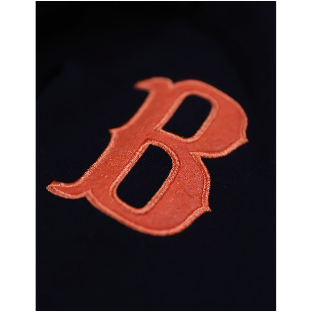 Baltimore Black Sox Heritage Hooded Sweatshirt (Sleeve Detail 2) - A close-up of a large embroidered orange-red letter 'B' on a dark navy or black fabric background.
