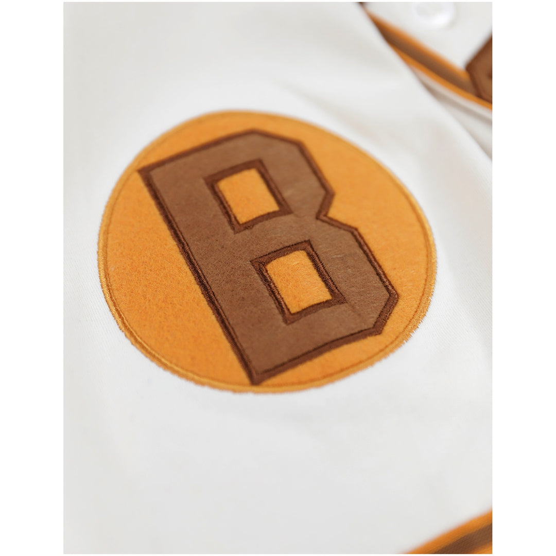 Baltimore Black Sox Negro Leagues Heritage Baseball Jersey (Sleeve Detail 2) - Close-up of a white garment featuring a circular tan patch with a large brown letter B.