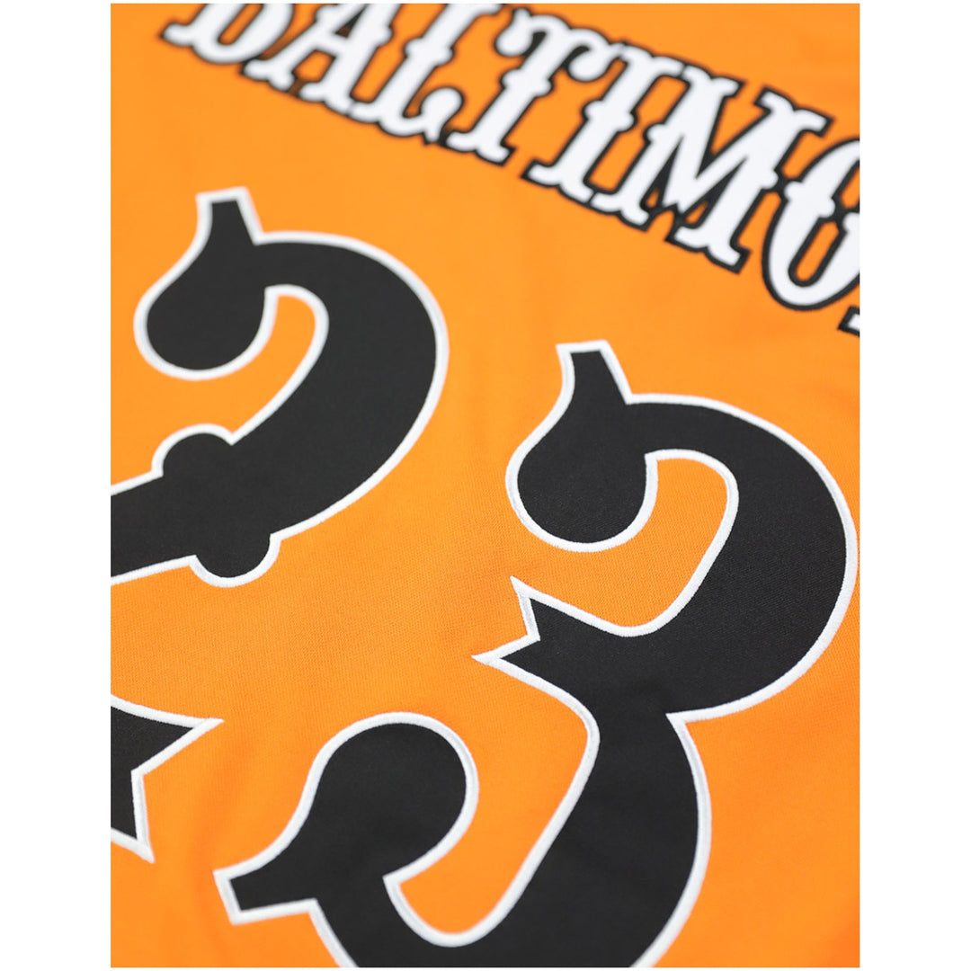 Baltimore Black Sox Legacy Baseball Jersey (Rear Detail) - Close-up of an orange sports jersey showing part of the name 'BALTIMORE' in white outlined letters and a large black number 23 with white outline.