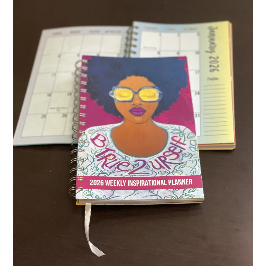 Be True to Yourself by Sylvia "Gbaby" Cohen: 2026 African American Weekly Inspirational Planner (Lifestyle Combo) - Planner with a colorful cover featuring a woman's face and text, on a dark surface.
