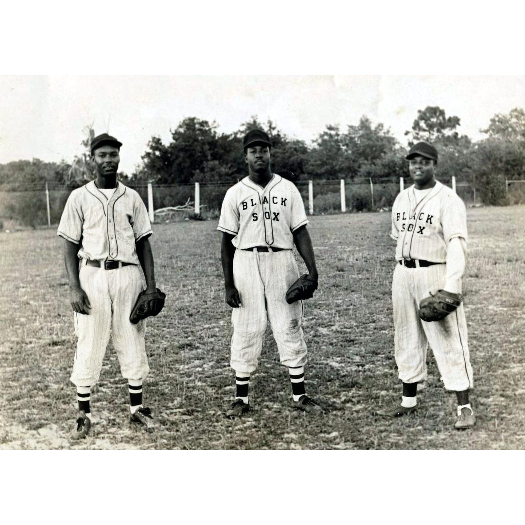 Baltimore Black Sox: Field Portrait (1920s) - Black and white vintage photograph of three baseball players standing on a field, wearing pinstriped uniforms with 'BLACK SEIX' across the chest and holding baseball gloves.