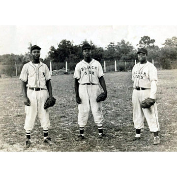 Baltimore Black Sox: Field Portrait (1920s) - Black and white vintage photograph of three baseball players standing on a field, wearing pinstriped uniforms with 'BLACK SEIX' across the chest and holding baseball gloves.