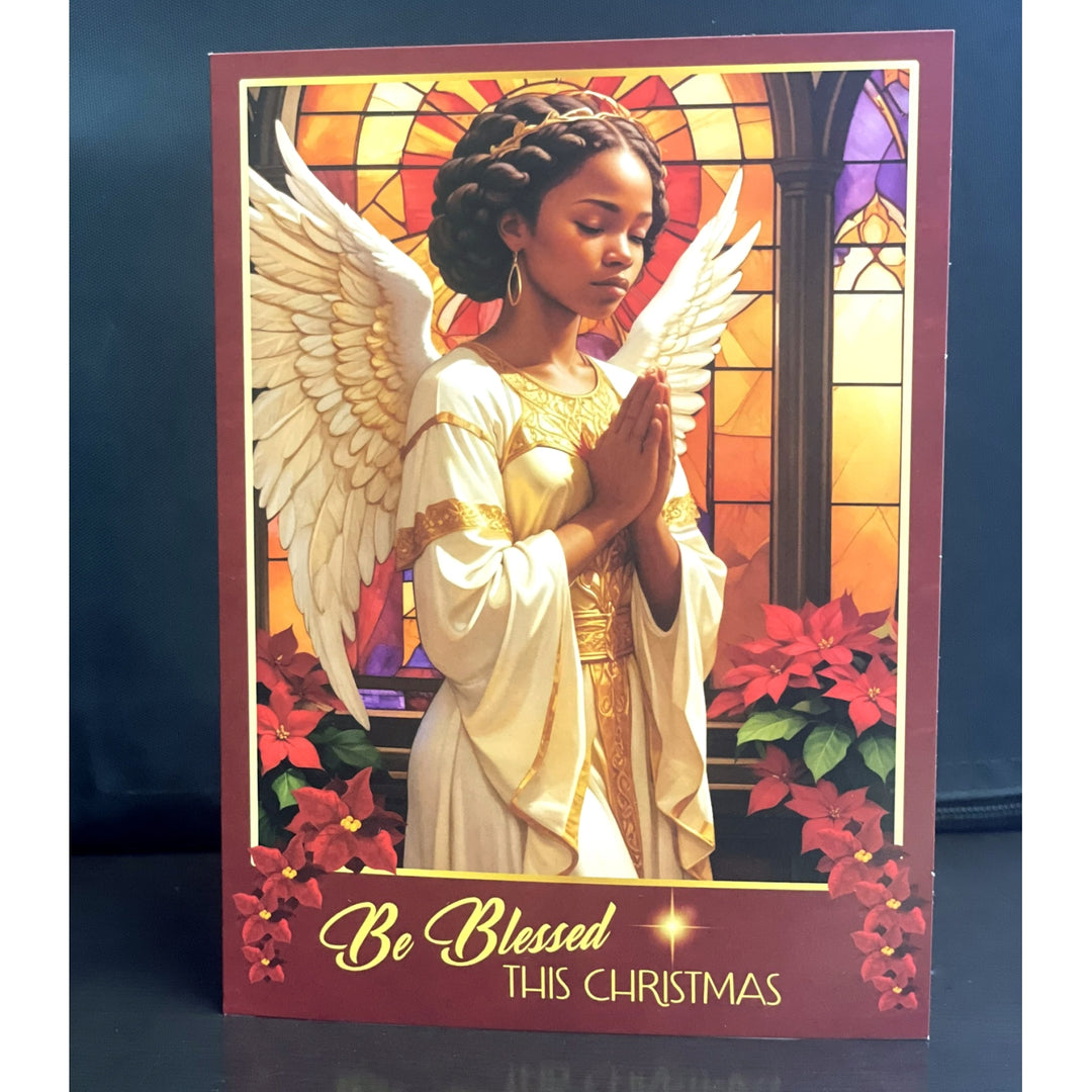Blessings Upon Blessings (Angel): Afrocentric Christmas Card Box Set (Lifestyle, Exterior) - Card with an angel illustration and 'Be Blessed This Christmas' text against a stained glass window background.