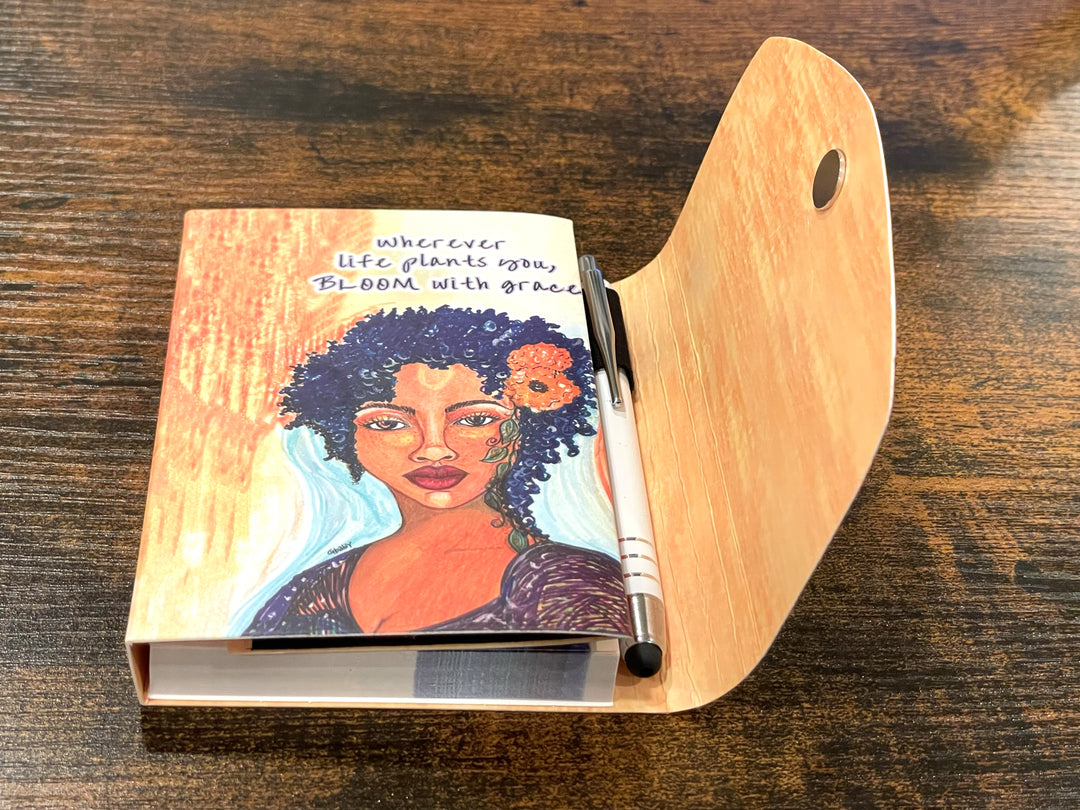 Bloom With Grace: African American Stylus Purse Pal by Sylvia "Gbaby" Cohen (Lifestyle) - Notebook with a colorful illustration of a woman on the cover, placed on a wooden surface.