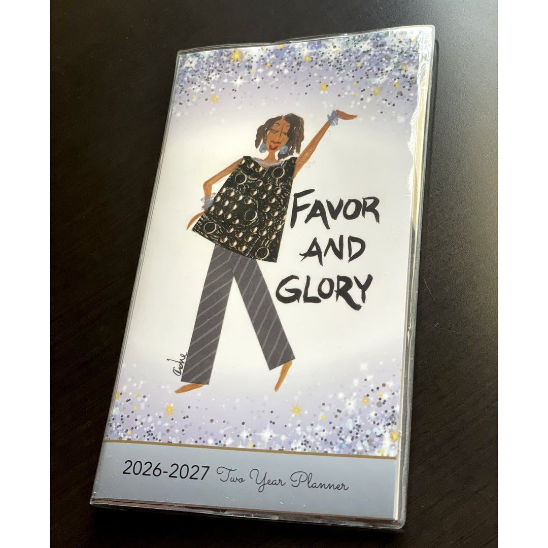 Favor and Glory by Cidne Wallace: 2026-2027 Two Year African American Pocket Calendar (Lifestyle Photo) - Two-year planner with a design of a woman and 'Favor and Glory' text on a dark surface.