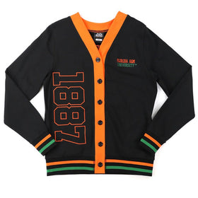 Florida A&M University Rattlers (FAMU) Women's Cardigan (Main) - A black varsity-style cardigan with bright orange trim, featuring '1887' in orange on the front, 'Turbin Air' and 'Nashville' embroidered on the chest, and orange and green striped accents on the cuffs and hem.