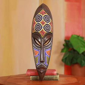 Ga Warrior (Asafoatse) African Mask (Lifestyle) - Ga warrior beaded mask styled as home wall decor resting on stacked books
