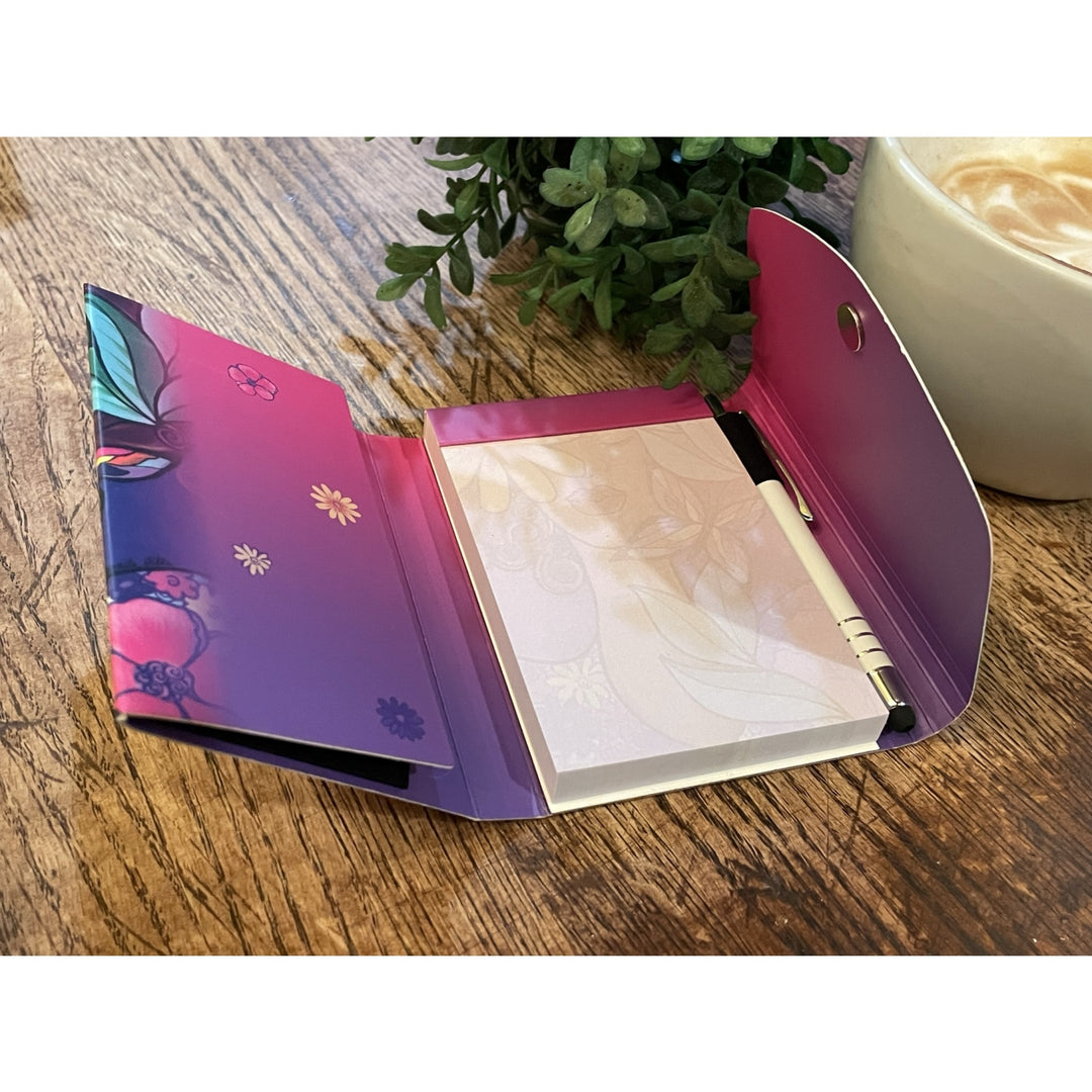 Garden Spirit: African American Stylus Purse Pal by Pamela Hills (Interior) - Open notebook with floral design on a wooden surface next to a cup of coffee and plant