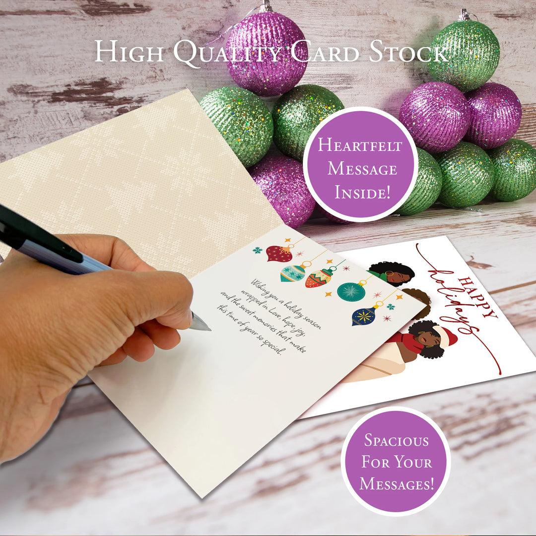 Happy Holidays: African American Christmas Card Box Set (Lifestyle 2) - Hand writing on a card with decorative Christmas balls and text about high-quality card stock and heartfelt messages.