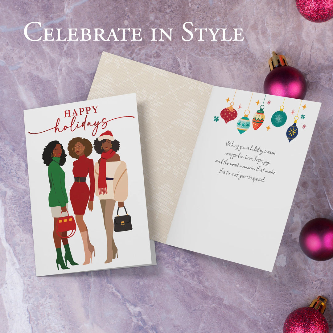 Happy Holidays: African American Christmas Card Box Set (Interior) - Holiday card with illustration of three women and 'Happy Holidays' text, surrounded by Christmas ornaments on a textured surface.