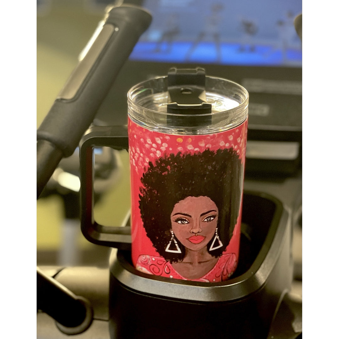 I am Powerful by Sylvia "GBaby" Cohen: Detla Sigma Theta Tumbler with Handle (Lifestyle) - A handled tumbler with a clear lid sits in a black cup holder on a treadmill. The tumbler features a graphic illustration of a woman with an afro hairstyle and geometric earrings against a pink background with white dots.