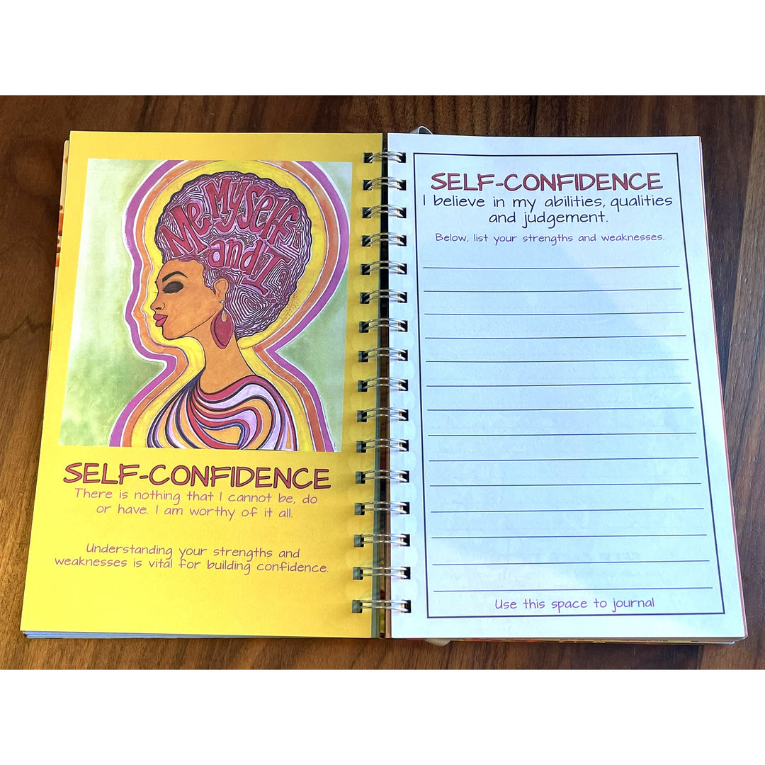 Love Yourself 2027 Weekly Inspirational Planner by Sylvia "Gbaby" Cohen (Journaling Pages) - An open spiral-bound journal showing two pages with 'Self-Confidence' prompts and illustrations, placed on a wooden surface.