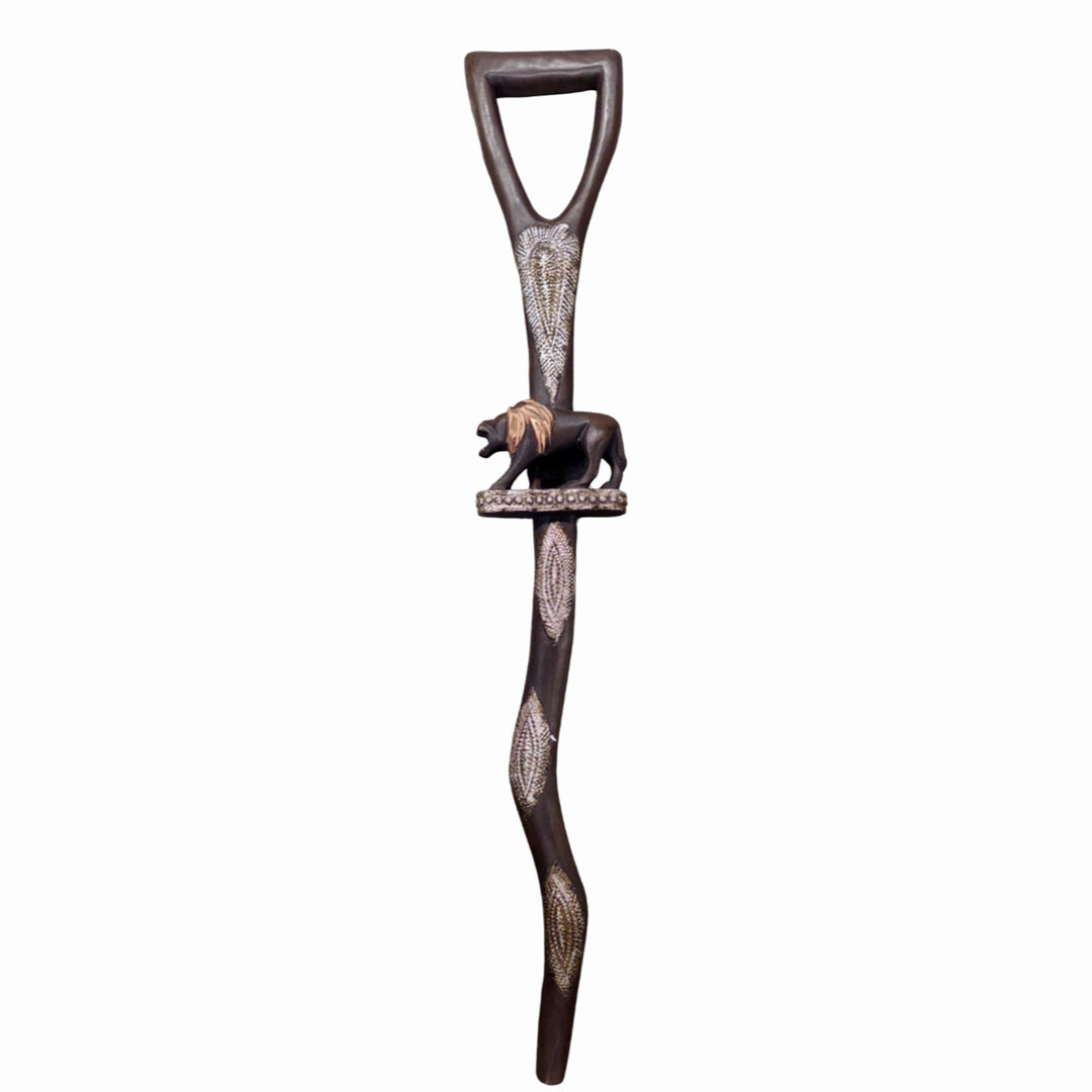 Royalty and Courage (Strolling Lion): Decorative African Wooden Walking Stick (Front) - A dark brown wooden decorative wall hook shaped like a spear handle, featuring carved geometric patterns and a small carved lion figure near the top, shown against a plain white background.