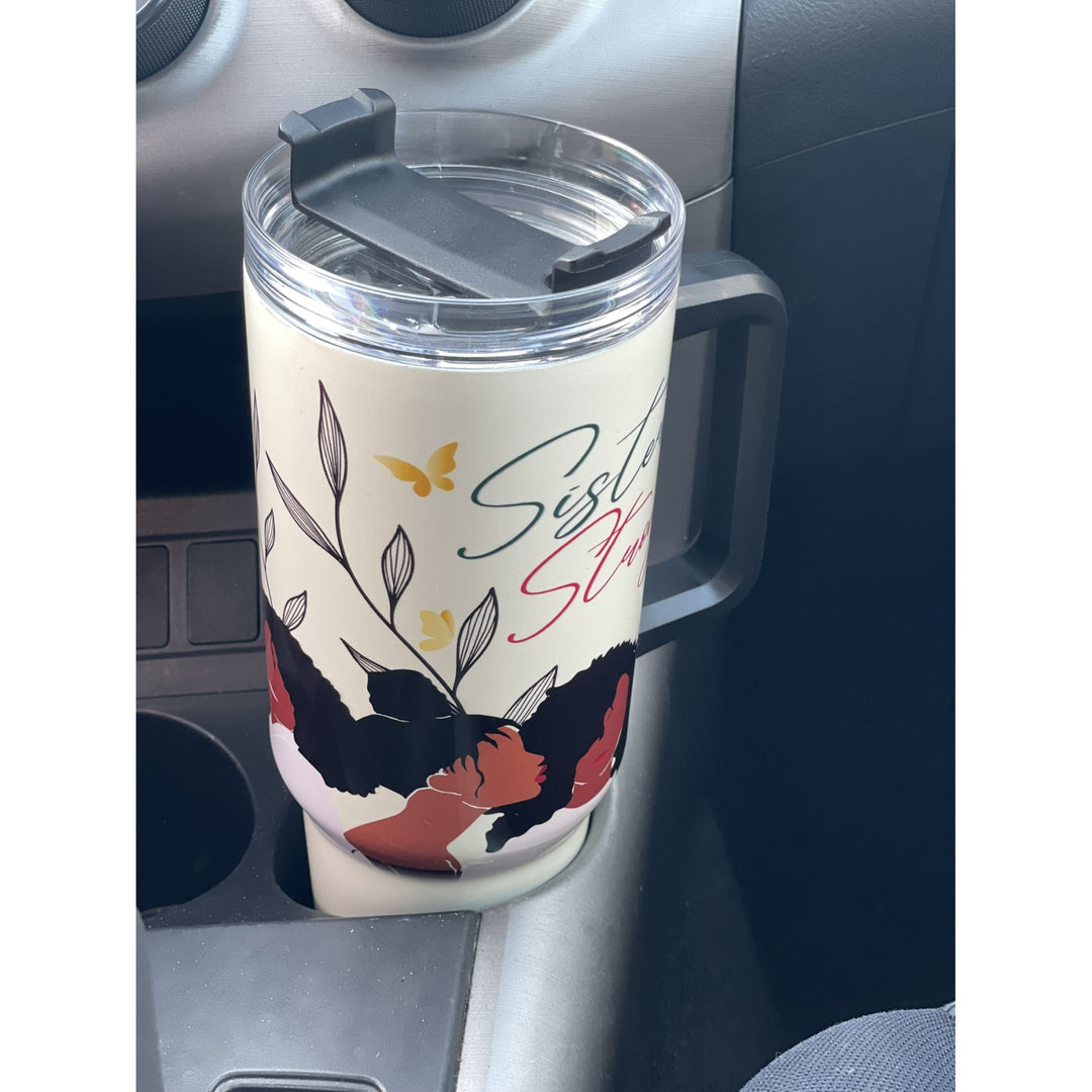 Sister Strong by Janine Robinson: African American 40 Ounce Tumbler with Handle (Lifestyle) - A cream-colored insulated travel tumbler with a handle and clear lid, sitting in a car cup holder. The tumbler features a graphic of a Black woman with a red face, black hair, and a red dress, with butterflies and leaves, and the text 'Sister Slow'.