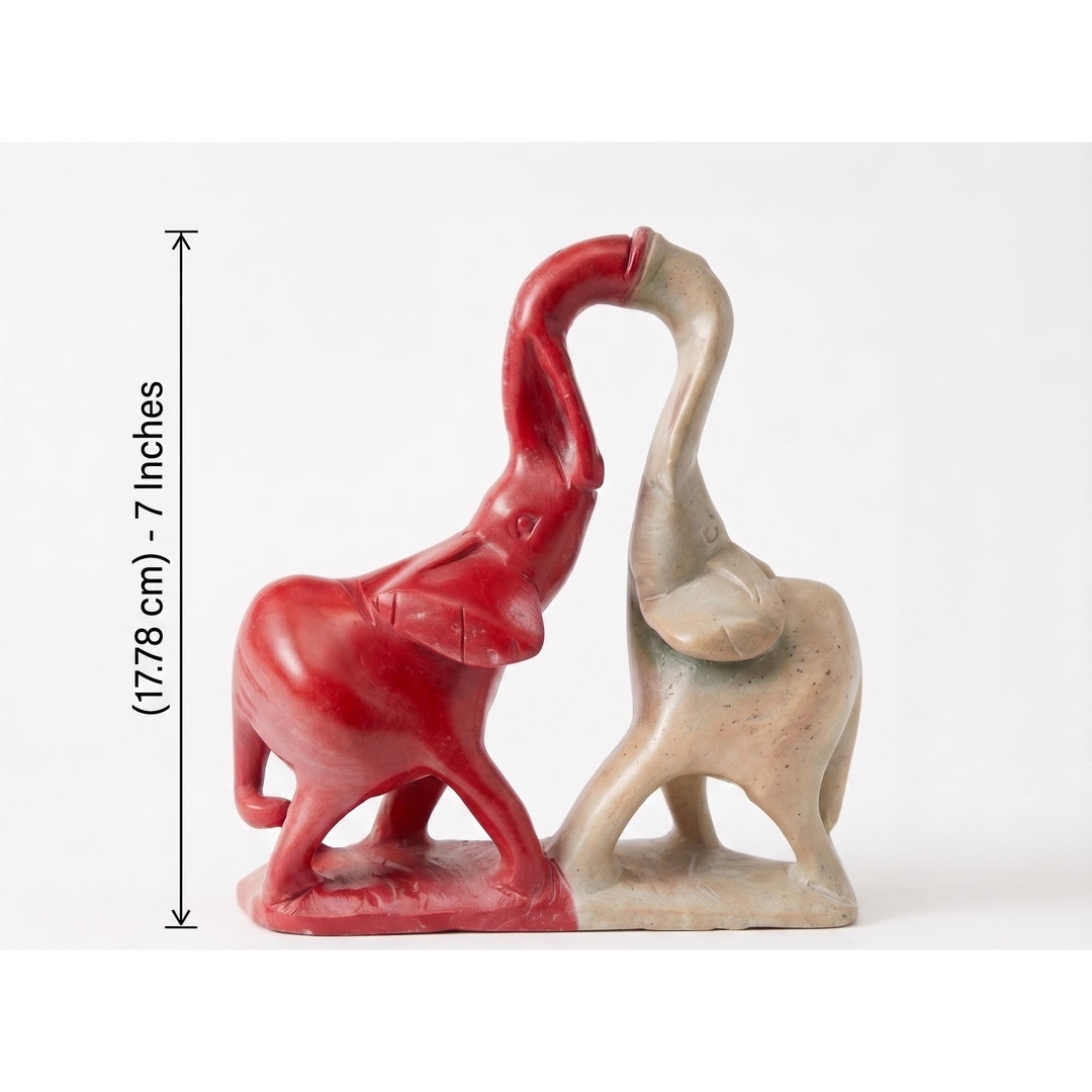 Sisterhood: The Bond | Red & White Soapstone Elephant Sculpture (Sizing Guide) - Two ceramic elephant figurines, one red and one beige, on a white background with a measurement label.