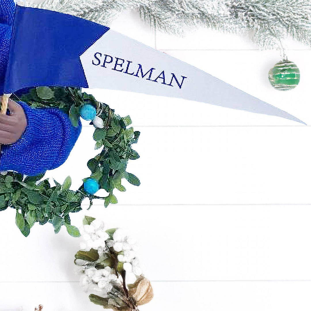 Blue and white Spelman pennant and berry wreath held by Santa figurine
