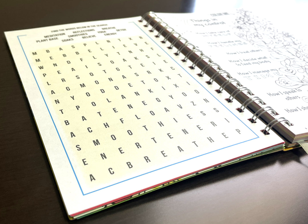 I Am Radiant by Syliva "Gbaby" Cohen: 2026 African American Weekly Inspirational Planner (Crossword Puzzle) - Open notebook with a word search page on a wooden surface