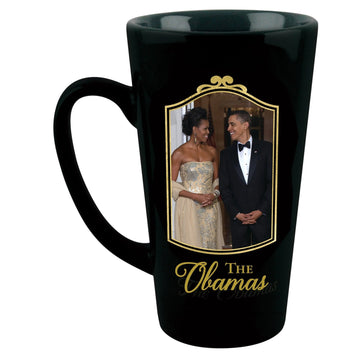 Class and Dignity: The Obamas Commemorative Ceramic Latte Mug (Front) - A black ceramic mug featuring a printed photo of Barack and Michelle Obama inside a gold frame, with 'The Obamas' written in gold script below the photo.