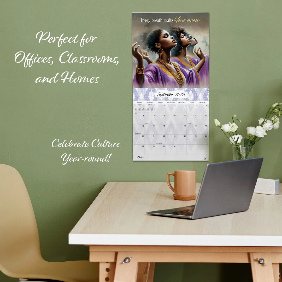 Total Praise: The Art of Greg Perkins 2026 African American Wall Calendar (Lifestyle) - Calendar on a wall above a desk with a laptop and mug, featuring text about its use in offices, classrooms, and homes.